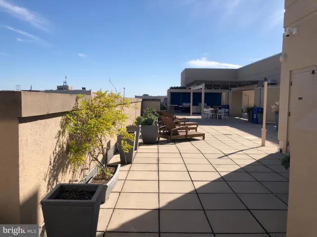 a living room with a black white checkered floor with couches a flat screen tv and a stove