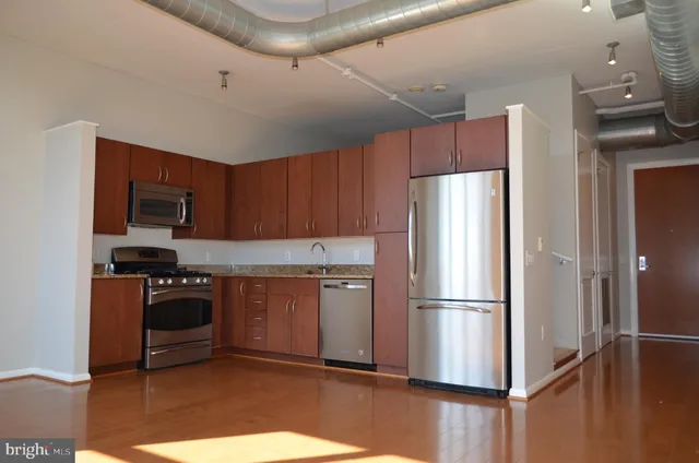 a kitchen with stainless steel appliances granite countertop a refrigerator stove and sink