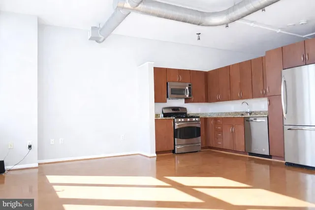 a kitchen with a refrigerator and a stove top oven