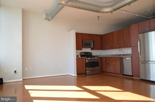 a kitchen with a refrigerator and a stove top oven