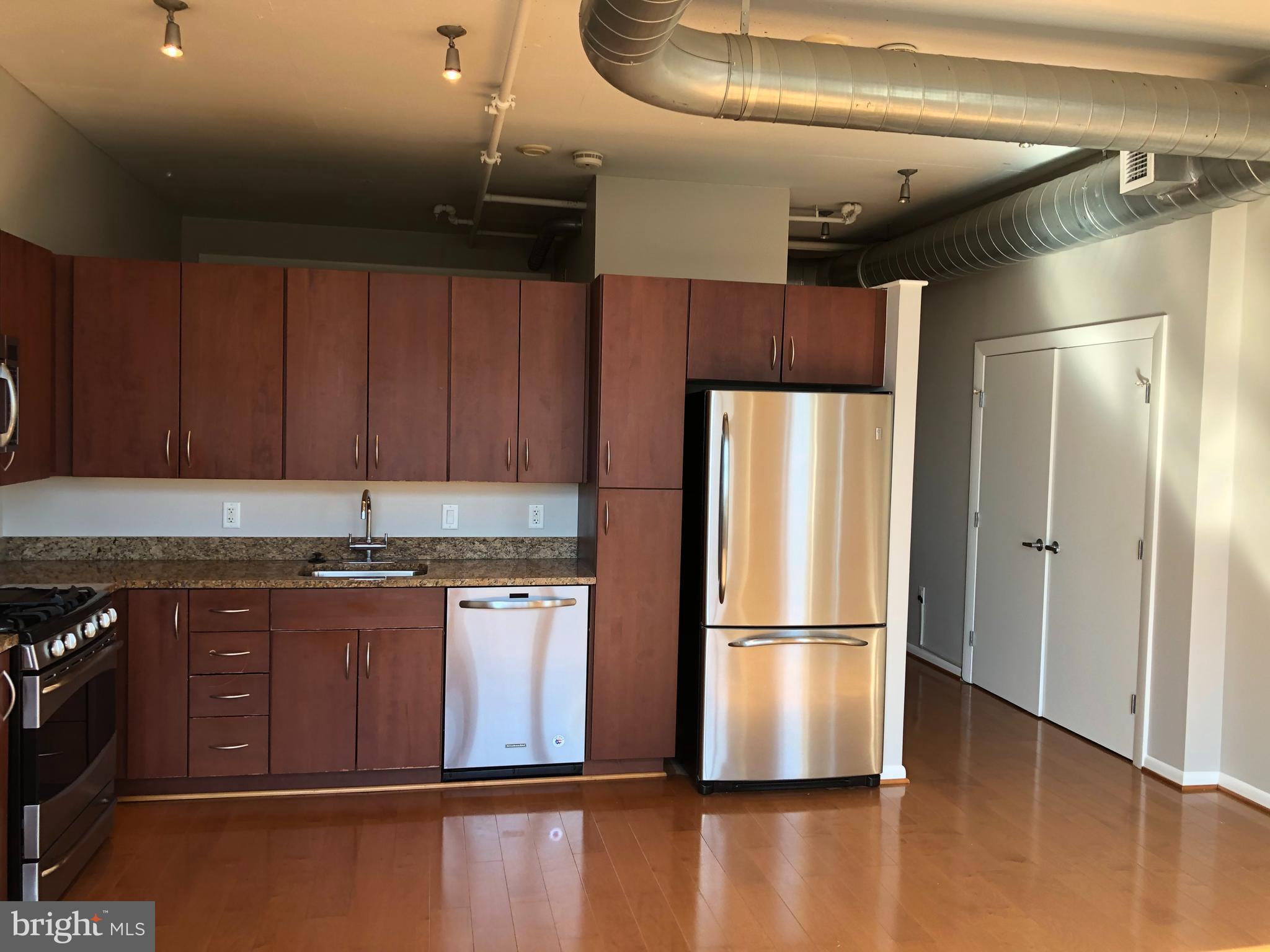 811 4th Street Northwest, Unit 1019 Washington, DC 20001 - Photo 10 of 38 a kitchen with granite countertop stainless steel appliances a refrigerator a sink a stove and cabinets