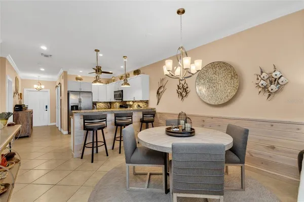 a dining room with wooden floor a chandelier a wooden table and chairs