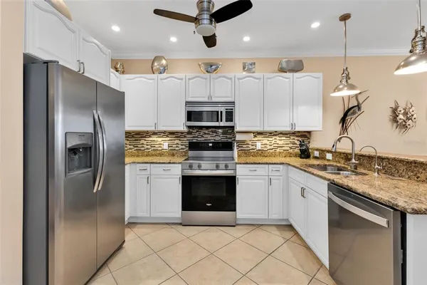 a kitchen with stainless steel appliances granite countertop a stove a refrigerator and a sink