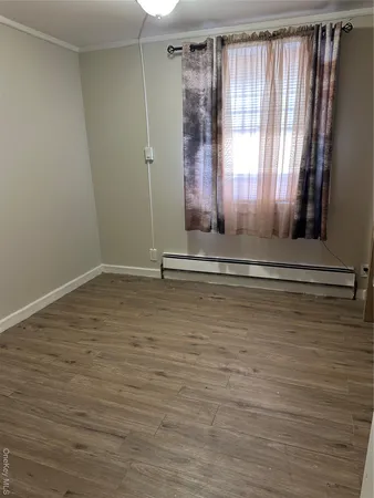 a view of a room with wooden floor and a window