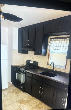 a kitchen with granite countertop a sink and a stove