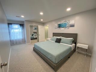 1014 Airport Road, Unit 105 Destin, FL 32541 - Photo 3 of 12 a spacious bedroom with a bed and a large mirror