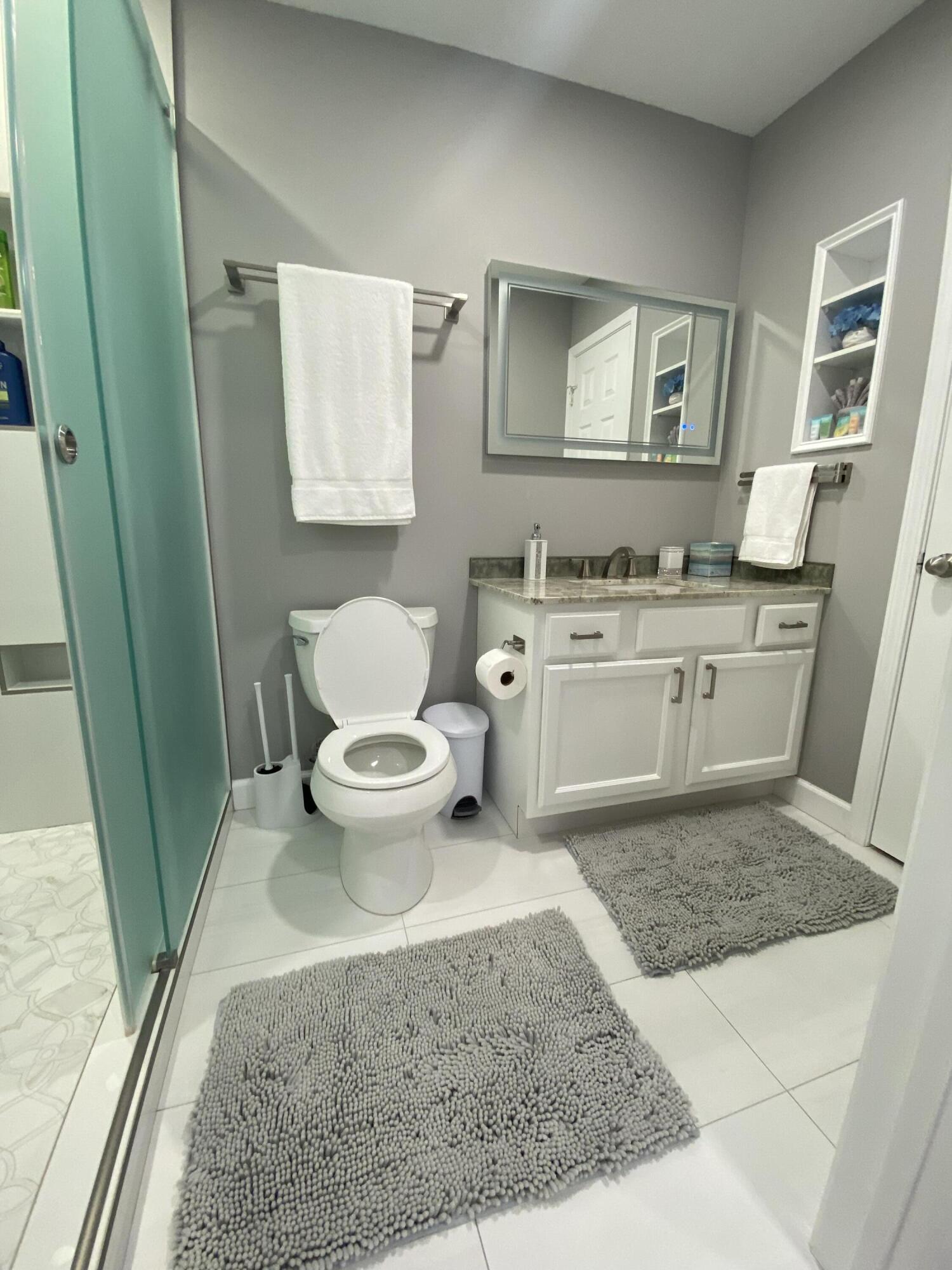 1014 Airport Road, Unit 105 Destin, FL 32541 - Photo 4 of 12 a bathroom with a sink toilet and mirror