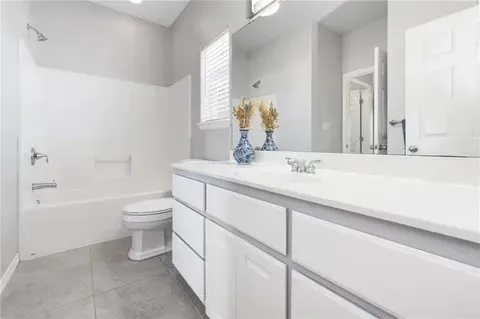 a bathroom with a granite countertop sink a toilet and bathtub