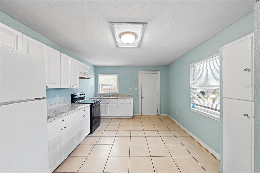 1846 Abacus Road Holiday, FL 34690 - Photo 14 of 20 a large white kitchen with a stove a sink dishwasher and cabinets