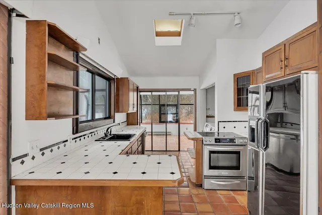 a kitchen with stainless steel appliances kitchen island granite countertop a stove and a refrigerator