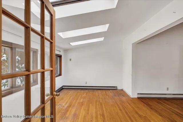 a view of an empty room with wooden floor and stairs