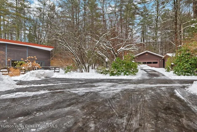 a backyard of a house with table and chairs under an umbrella