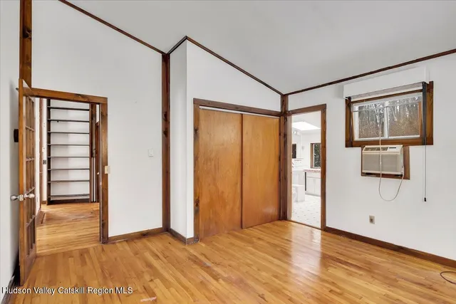 a view of a hallway with wooden floor and cabinet