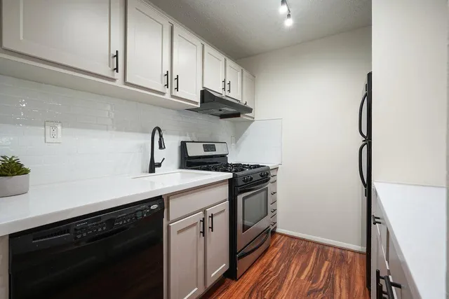 a kitchen with stainless steel appliances a sink dishwasher stove and refrigerator