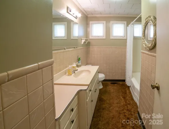 a bathroom with a sink and mirror with bathtub