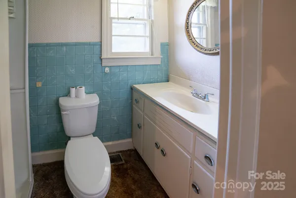 a bathroom with a toilet sink and mirror