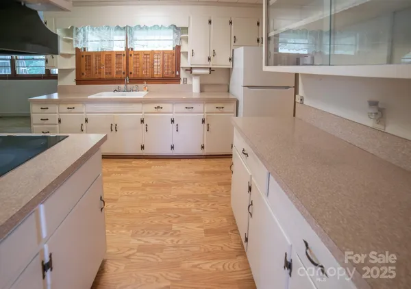 a large kitchen with kitchen island a sink stove and cabinets