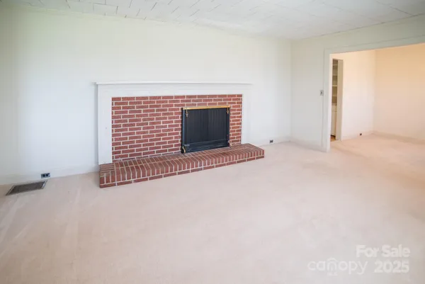 a view of an empty room with a fireplace