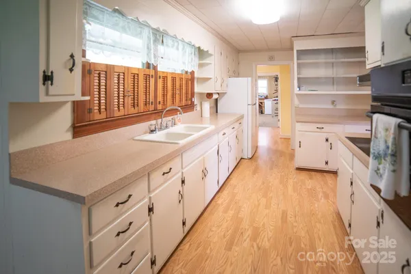 a kitchen with a sink stove and wooden floor