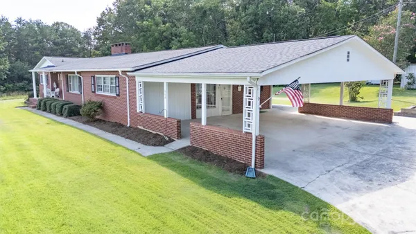 a view of a house with a yard and porch