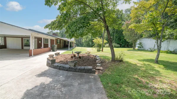 a view of a house with backyard and trees