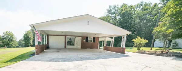 a view of a house with backyard and trees