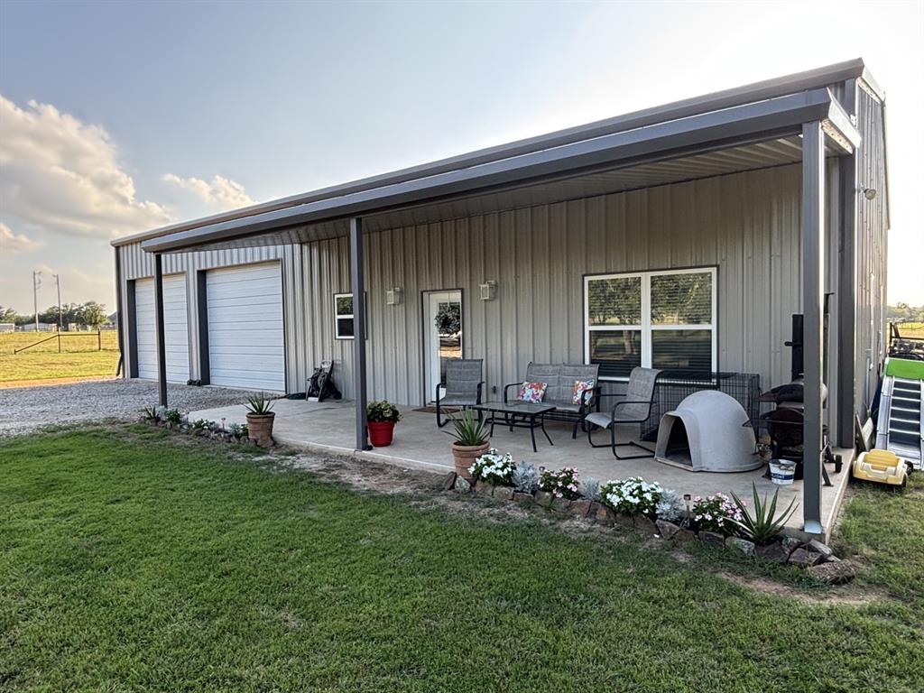 1020 Turkey Meadows Weatherford, TX 76088 - Photo 2 of 21 Rear view of property with a yard, board and batten siding, outdoor lounge area, and driveway