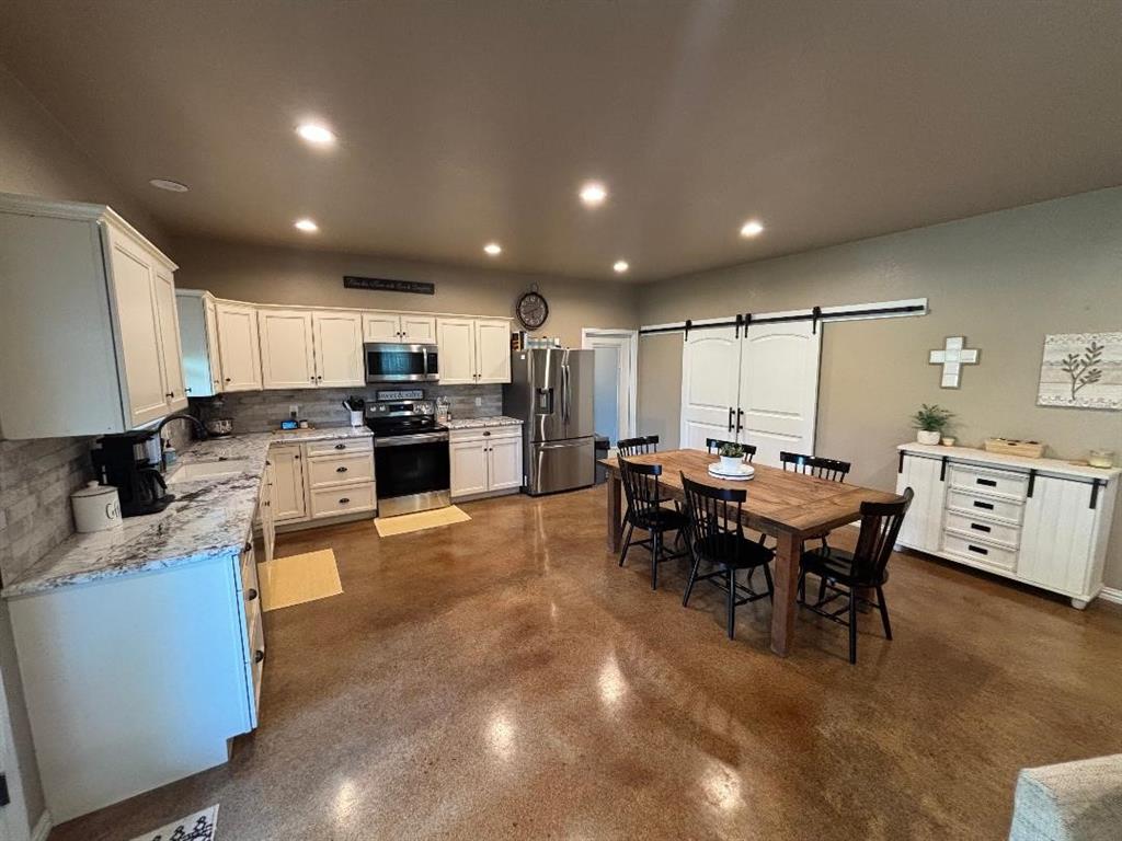 1020 Turkey Meadows Weatherford, TX 76088 - Photo 6 of 21 Dining area featuring recessed lighting, a barn door, and finished concrete flooring