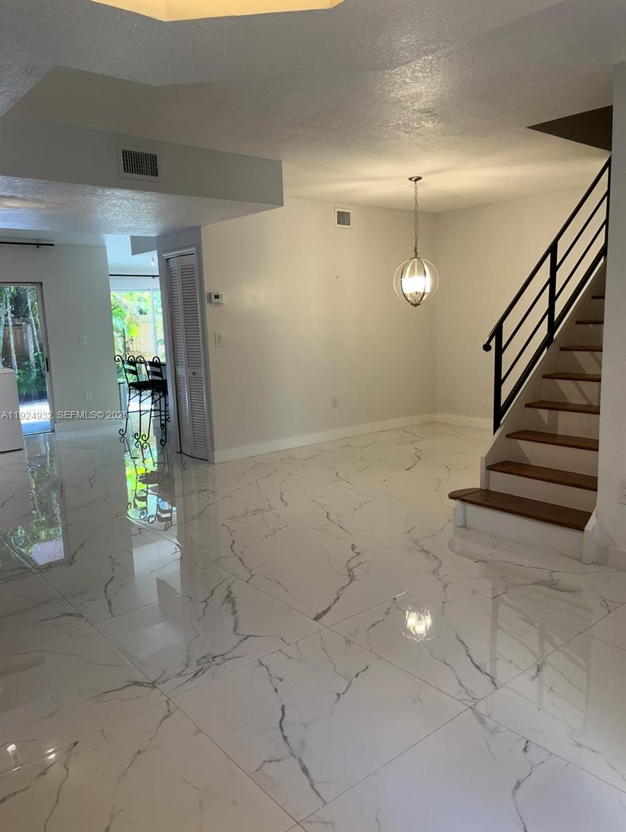 10150 Southwest 88th Street, Unit 103 Miami, FL 33176 - Photo 11 of 29 an empty room with wooden floor and windows