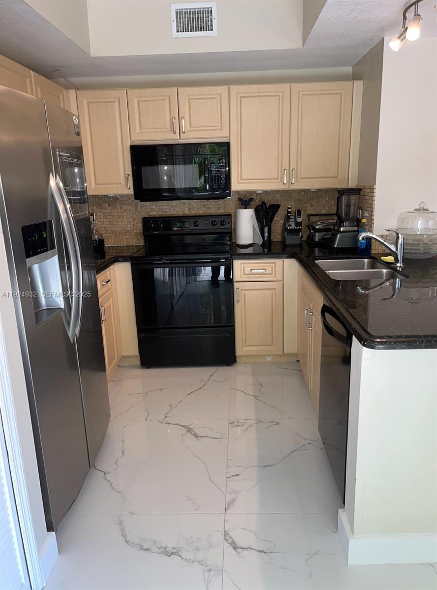 10150 Southwest 88th Street, Unit 103 Miami, FL 33176 - Photo 2 of 29 a kitchen with a sink a stove and refrigerator