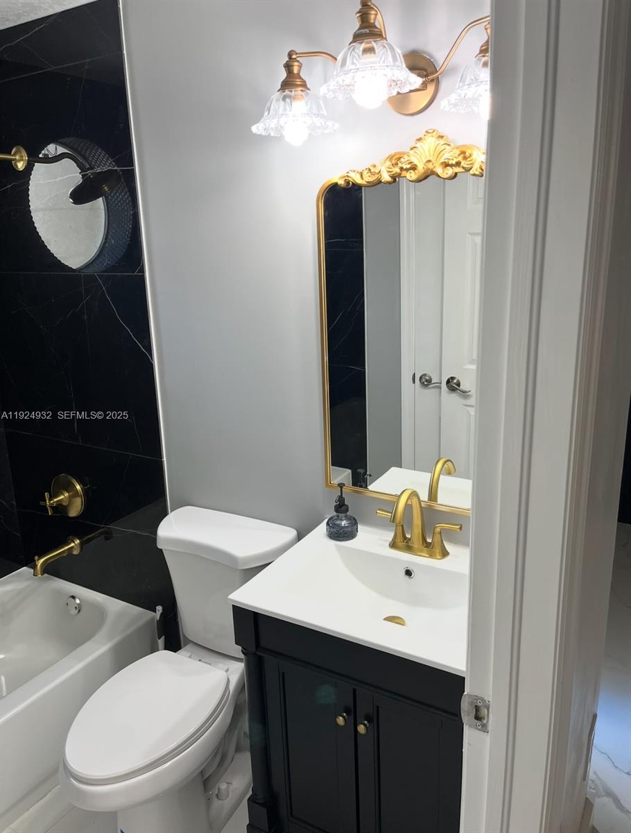 10150 Southwest 88th Street, Unit 103 Miami, FL 33176 - Photo 9 of 29 a bathroom with a toilet sink and mirror