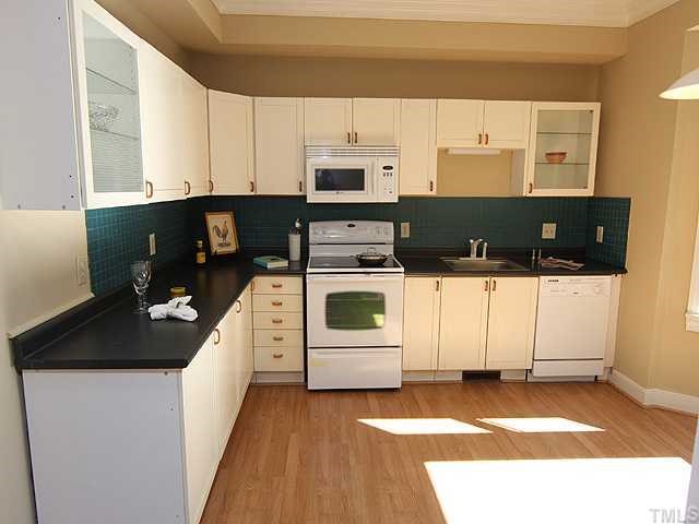 1318 Slatestone Court Raleigh, NC 27615 - Photo 5 of 12 a kitchen with a stove and white cabinets