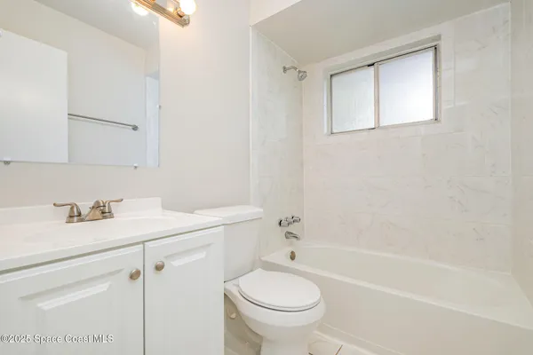 a bathroom with a sink toilet vanity granite tub and shower