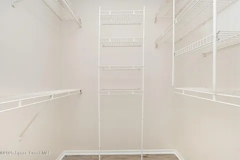 a view of a room with wooden floor and a ceiling fan