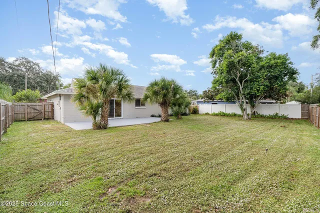 a view of an house with backyard and tree