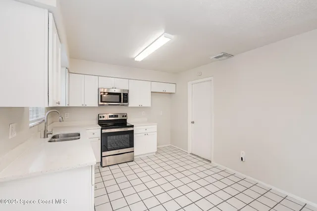 a kitchen with stainless steel appliances granite countertop a sink and cabinets