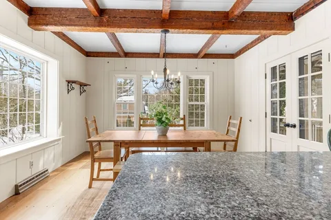 a view of a dining room with furniture large windows and wooden floor