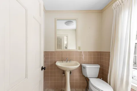 a bathroom with a sink a toilet and mirror