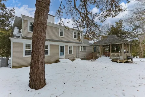 a front view of a house with a yard covered in snow