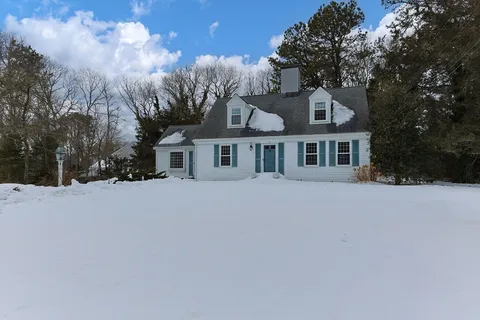 a front view of a house with a yard covered in snow