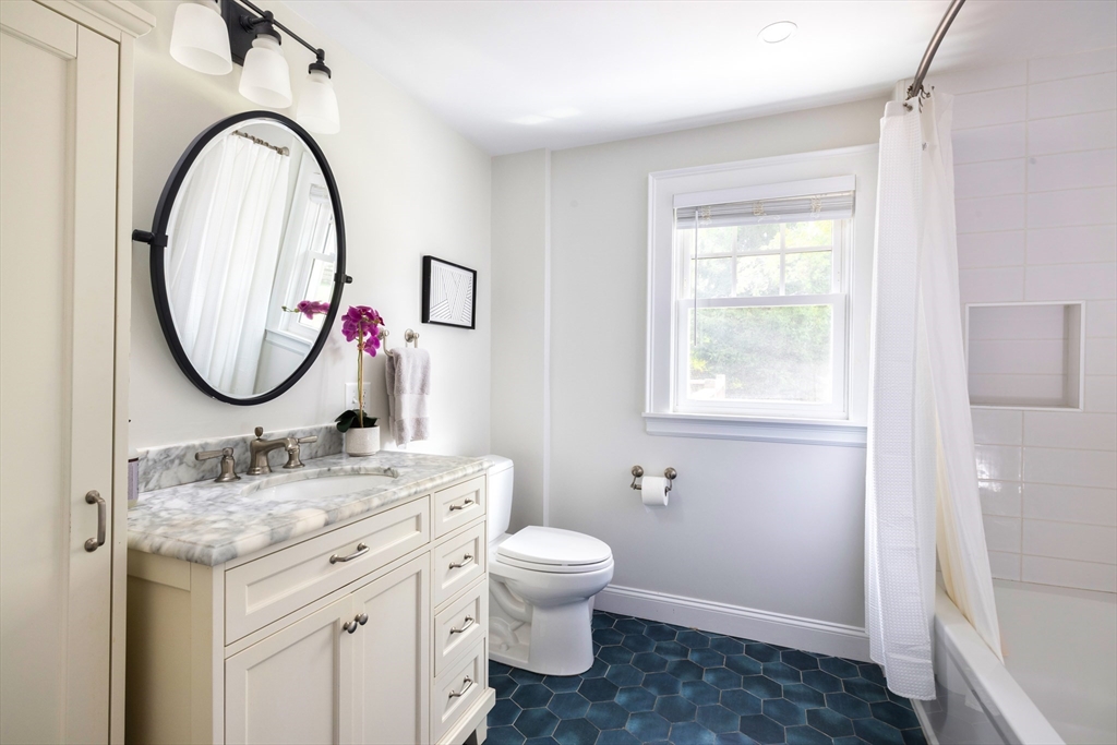 18 Wolcott Road Brookline, MA 02467 - Photo 15 of 19 a bathroom with a granite countertop toilet a sink and a mirror