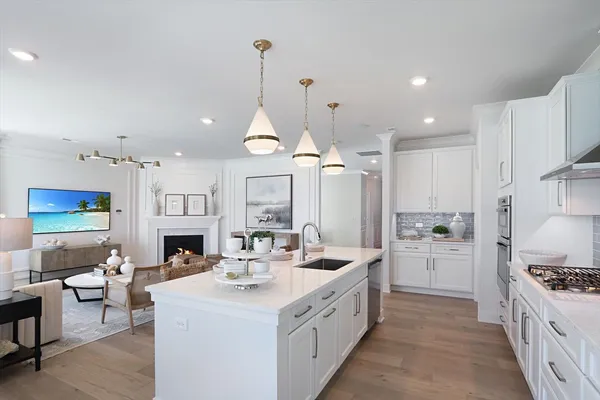 a large kitchen with stainless steel appliances kitchen island granite countertop a sink and a refrigerator