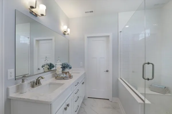 a bathroom with double vanity sink and mirror