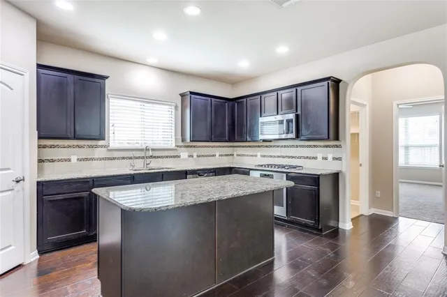 a kitchen with stainless steel appliances granite countertop a sink stove and refrigerator