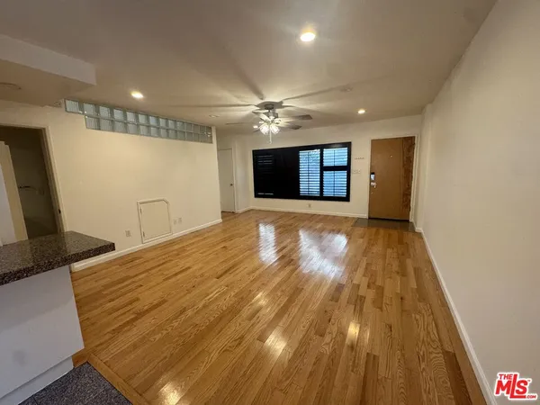 a view of empty room with wooden floor