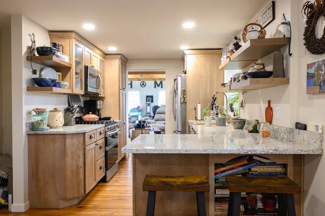 a large kitchen with granite countertop lots of counter space and stainless steel appliances