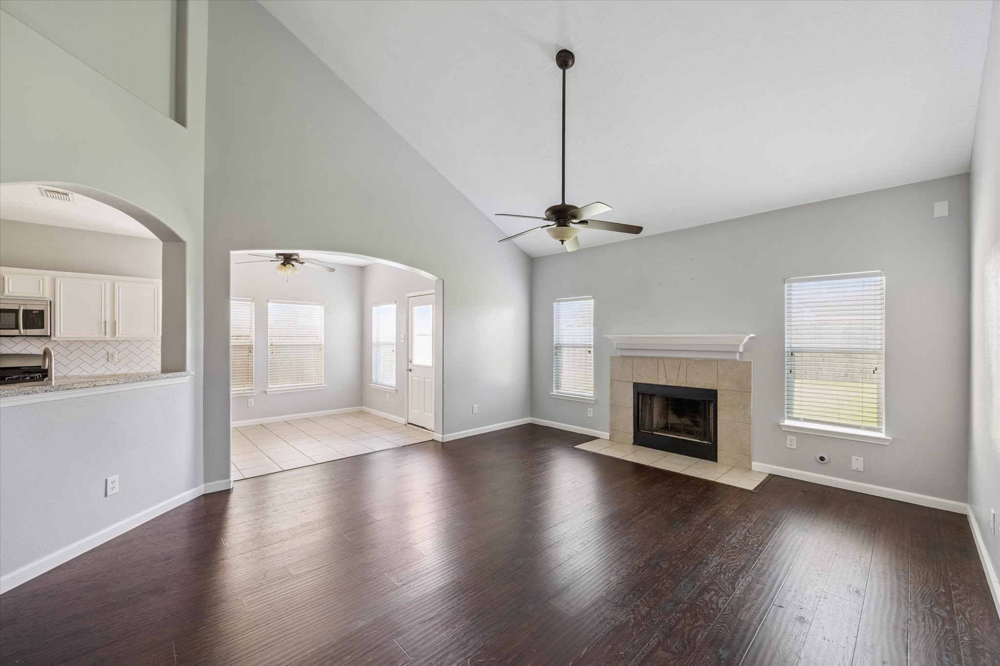 18239 Eton Ridge Court Richmond, TX 77407 - Photo 3 of 10 a view of an empty room with wooden floor fireplace and a window