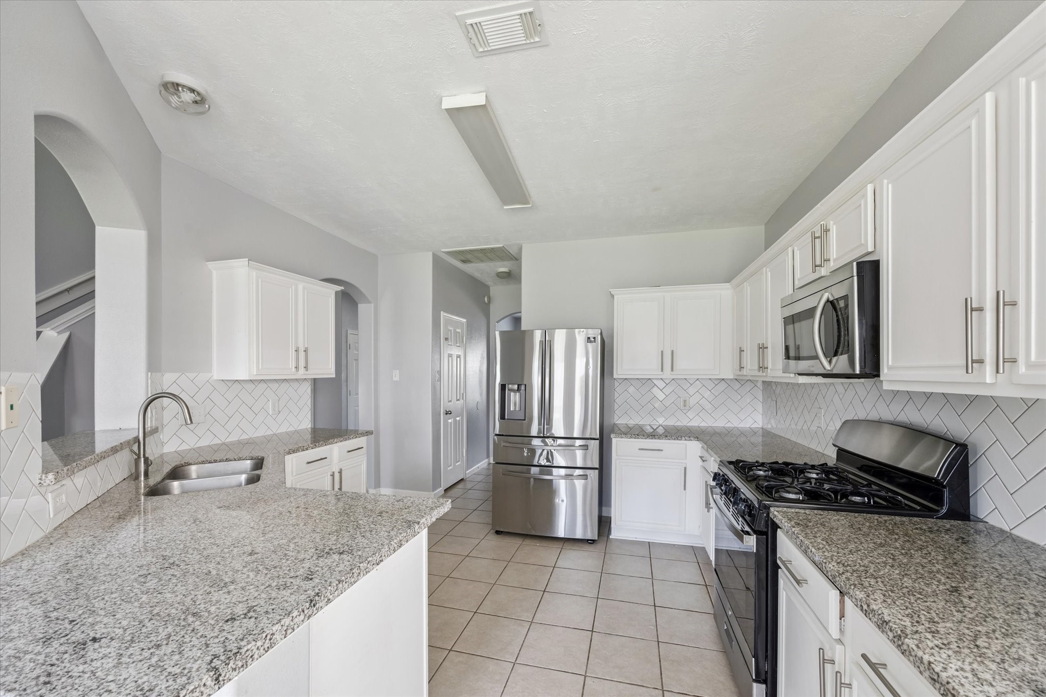 18239 Eton Ridge Court Richmond, TX 77407 - Photo 6 of 10 a kitchen with stainless steel appliances granite countertop a sink stove and refrigerator