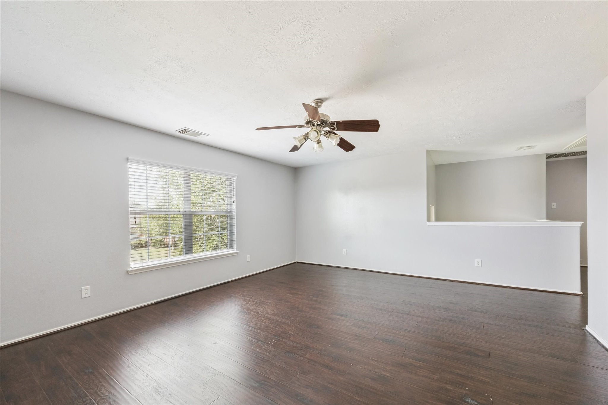18239 Eton Ridge Court Richmond, TX 77407 - Photo 9 of 10 a view of an empty room with wooden floor and a window