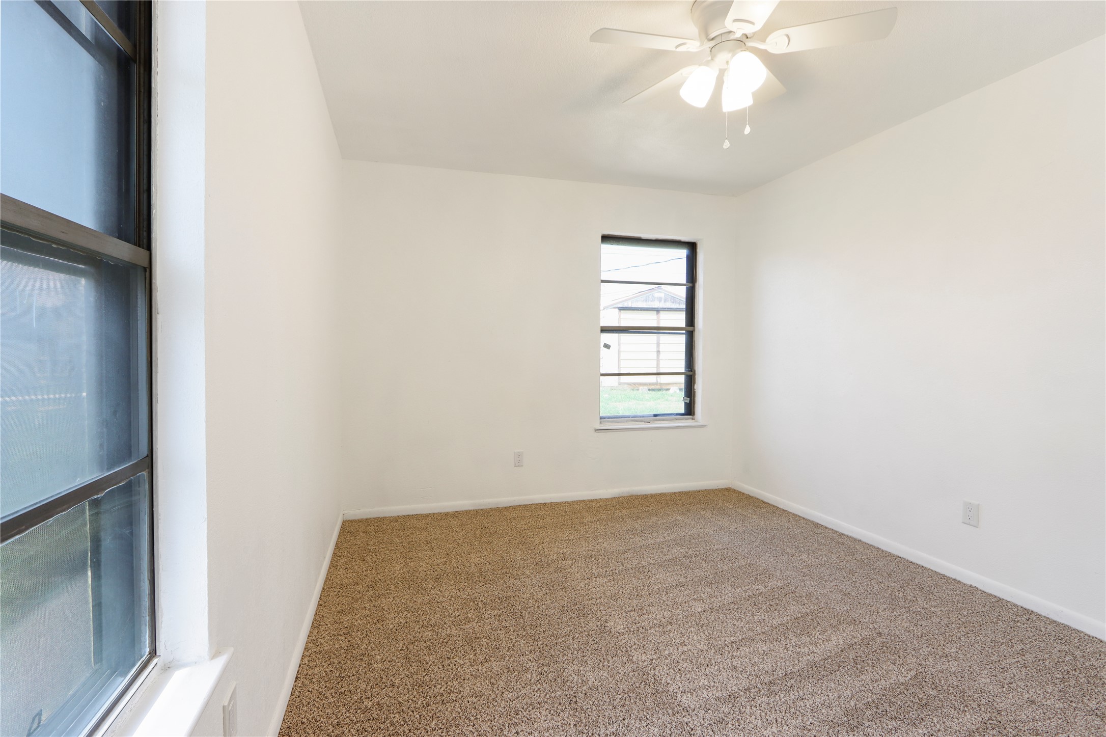 9100 Shepard Drive Austin, TX 78753 - Photo 19 of 26 an empty room with a chandelier fan and windows